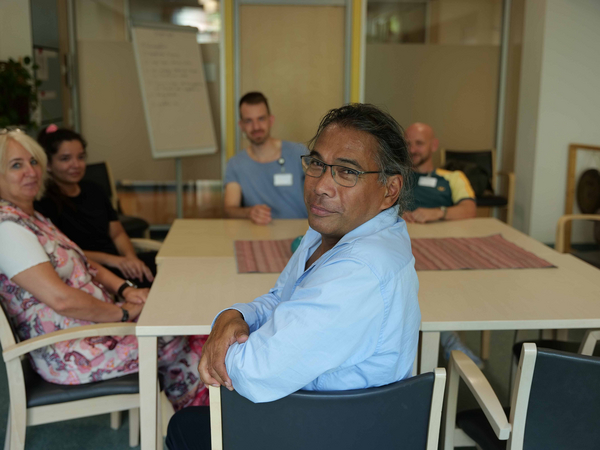 Ein Mitarbeiter blickt in die Kamera an einem Tisch mit mehreren Personen im Hintergrund bei einer Besprechung in der Klinik für Psychiatrie und Psychotherapie im Albertinen Krankenhaus in Hamburg. Ein Mitarbeiter blickt in die Kamera an einem Tisch mit mehreren Personen im Hintergrund bei einer Besprechung in der Klinik für Psychiatrie und Psychotherapie im Albertinen Krankenhaus in Hamburg.