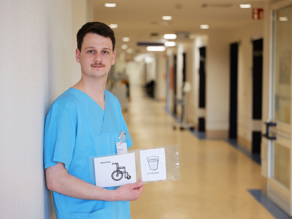 Kilian Müller, Stationsleitung der neurologischen Frührehabilitation im Albertinen Krankenhaus, zeigt Piktogramme zur Unterstützung der Kommunikation mit Patientinnen und Patienten nach Schlaganfall Kilian Müller, Stationsleitung der neurologischen Frührehabilitation im Albertinen Krankenhaus, zeigt Piktogramme zur Unterstützung der Kommunikation mit Patientinnen und Patienten nach Schlaganfall