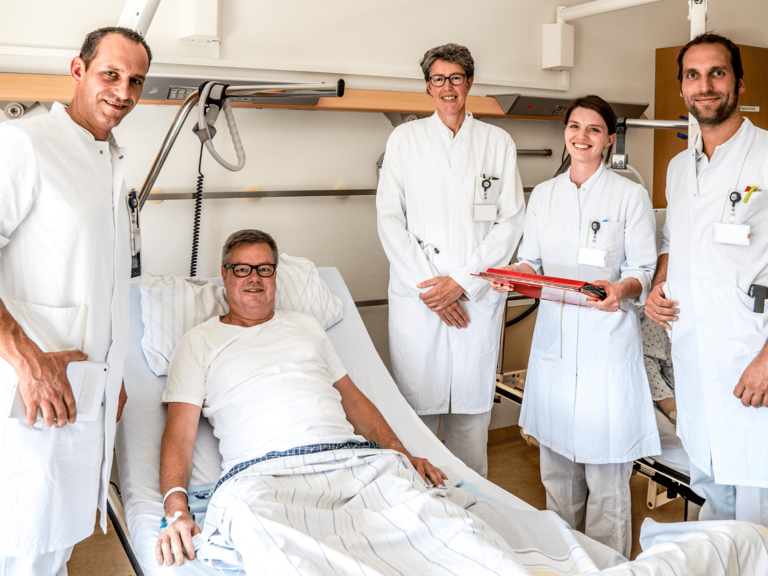Ärztinnen und Ärzte bei einem Patienten am Bett - Allgemein- und Viszeralchirurgie - Albertinen Krankenhaus Hamburg 