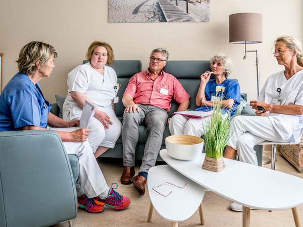 Ein interdisziplinäre Team aus fünf Personen sitzt überwiegend in Funktionskleidung zu einer Besprechung in einem hell und modern eingerichteten Raum der Klinik für Innere Medizin mit Schwerpunkt Palliativmedizin im Albertinen Krankenhaus in Hamburg. Ein interdisziplinäre Team aus fünf Personen sitzt überwiegend in Funktionskleidung zu einer Besprechung in einem hell und modern eingerichteten Raum der Klinik für Innere Medizin mit Schwerpunkt Palliativmedizin im Albertinen Krankenhaus in Hamburg.