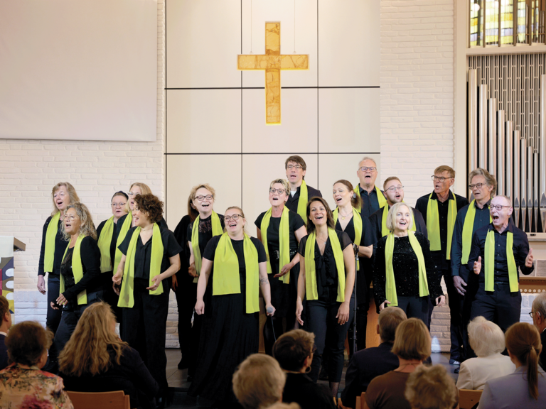 Die Mitglieder des Albertinen-Mitarbeitenden-Gospelchors singen bei einem Gospelkonzert auf der Bühne der Kiche beim Albertinen Krankenhaus in festlicher schwarzer Kleidung mit grünen Schals. Die Mitglieder des Albertinen-Mitarbeitenden-Gospelchors singen bei einem Gospelkonzert auf der Bühne der Kiche beim Albertinen Krankenhaus in festlicher schwarzer Kleidung mit grünen Schals.